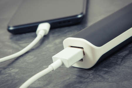 External black powerbank charging empty battery of smartphone or mobile phoneの写真素材