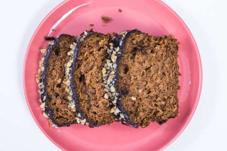 Fresh baked homemade pastry made of zucchini with nuts and raisins. White background