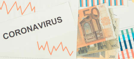 Inscription coronavirus, currencies euro and declining chart as risk of global financial crisis caused by virus. Covid-19の写真素材