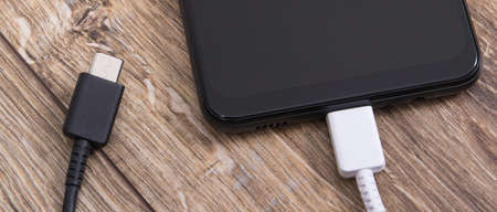 Smartphone with charger cables. Mobile phone charging concept