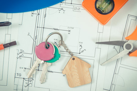 Keys with house shape and electrical construction drawings with work tools for engineering jobs. Building or buying home concept. technologyの写真素材