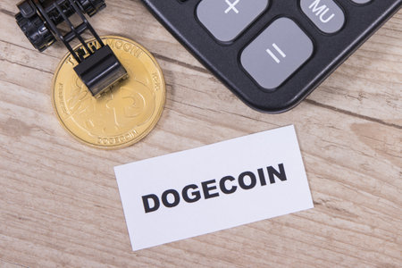 Dogecoin, miniature excavator and calculator. Symbol of cryptocurrency. International network payment. finance conceptの写真素材