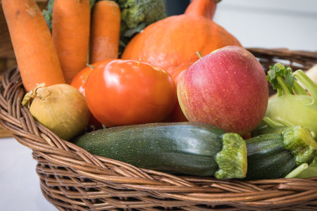 Fresh nutritious fruits and vegetables in basket as ingredients for cooking containing healthyの写真素材