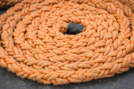 Thick rope coiled on deck of ship or yacht. Detail and part of shipsの写真素材