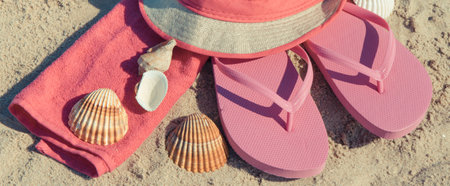 Various accessories using for relax on beach. Straw hat, pink flip flop and fluffy towel. Summertimeの写真素材