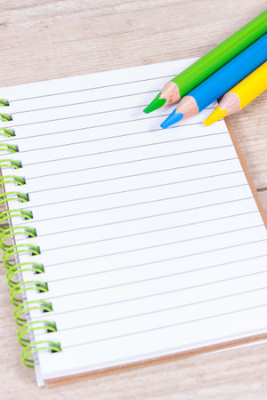 Notebook for notes and colorful crayons. Office and stationery accessories used at school or...