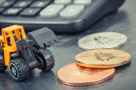 Bitcoin coins, miniature excavator and calculator. Symbol of cryptocurrency and international network payment. Finance conceptの写真素材