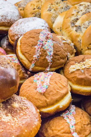 Fresh baked glazed donuts and other cookies on market stall or in grocery shop. Delicious crunchy...