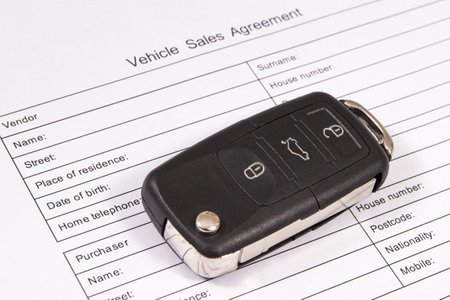 Black car key and vehicle sales agreement. Sales or purchases new or used vehicle. Transportationの写真素材