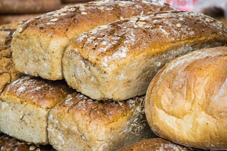 Fresh baked traditional loaves of wheat or rye bread on market stall or in bakery
