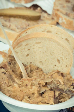 Fresh prepared traditional Polish dish bigos with pieces of wheat bread and bread with lardの写真素材