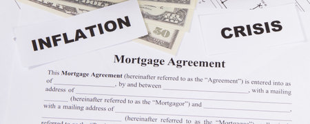 Mortgage agreement form, dollar bills and inscriptions inflation and crisis. High prices of real...