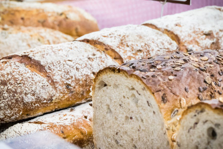 Fresh baked traditional loaves of wheat or rye bread on market stall or in bakery