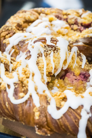 Fresh baked crusty bun with icing on market stall, in cafe or in confectionery shopの写真素材
