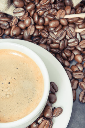 Coffee in white cup and roasted fragrant coffee beansの写真素材