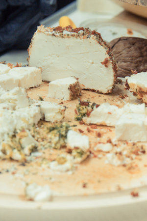 Fresh smoked cheese with spices for sale on stall or in grocery shopの写真素材