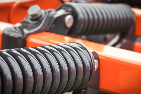 Steel black spring as detail and part of agricultural machine. Technology