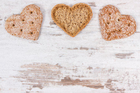 Portion of bread in shape of heart baked from whole grain flour. Place for text or inscription on...