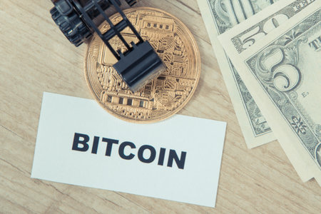 Bitcoin coin, miniature excavator and dollars. Symbol of cryptocurrency. International network payments. Finance conceptの写真素材