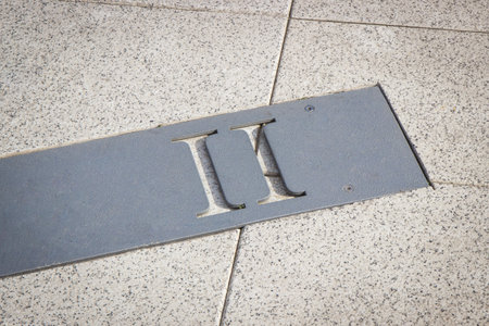 Roman numerical number two made of stone tiles on street in city