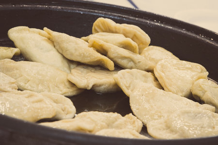 Fresh prepared fried homemade dumplings on frying pan. Traditional Polish foodの写真素材