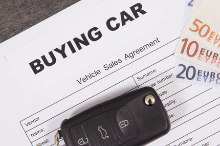 Black car key, euro banknotes and vehicle sales agreement. Inscription buying a car. Sales or purchases of automobiles. Transportationの写真素材