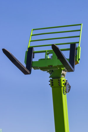 Forklift loader or stacker on blue sky background. Detail and part of hydraulic and pneumatic...