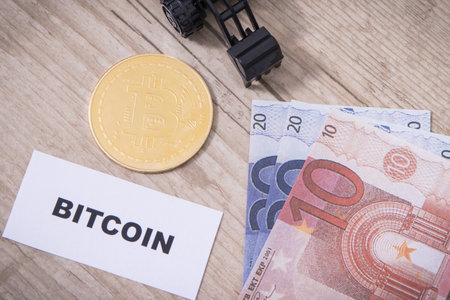Bitcoin coin, miniature excavator and euro. Symbol of cryptocurrency. International network...