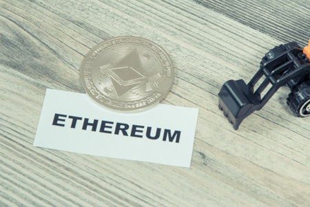 Ethereum coin and miniature excavator. Symbol of cryptocurrency. International network payments....