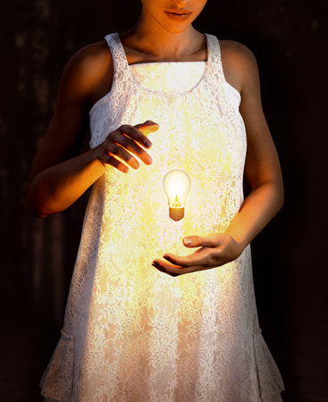 Surreal image of a young beautiful woman levitating a burning glowing lightbulb between her hands, creativity concept, 3d renderの写真素材