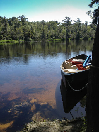 Canoe waits on the riverbank loaded for adventureの写真素材