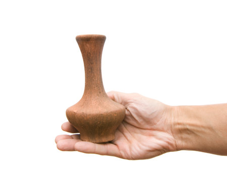 Clay jug in a hand on a white backgroundの写真素材