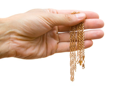 Gold chain in a hand on a white backgroundの写真素材