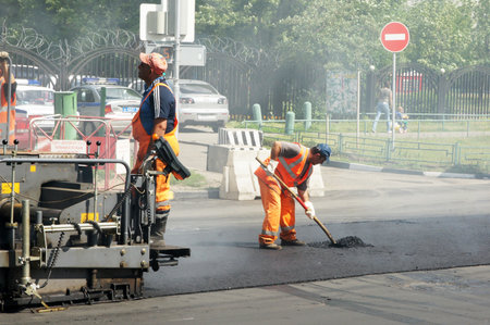 MOSCOW - JUNE 22: The brigade of visitors workers repairs road under the program of planned repair in area Marino on JUNE 22, 2011 In 2011 in Moscow will repair 23,5 million in sq.m. of roadsのeditorial素材
