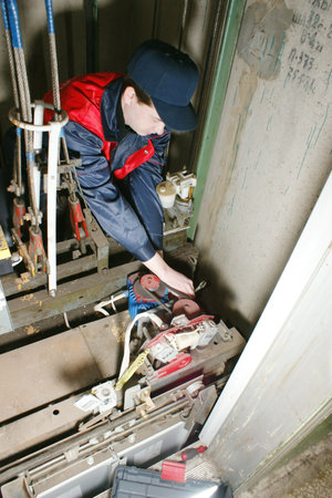 The master repairs the lift equipment in an apartment houseのeditorial素材