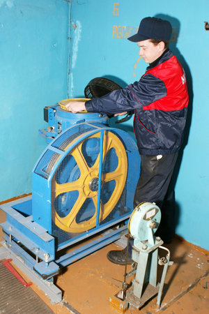 The master repairs the lift equipment in an apartment house