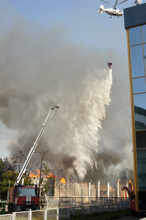 MOSCOW - AUGUST 30: Fire helicopters extinguish a fire in pavilion Veterinary fire at the All-Russia Exhibition Centre on AUGUST30, 2011 in Moscowのeditorial素材