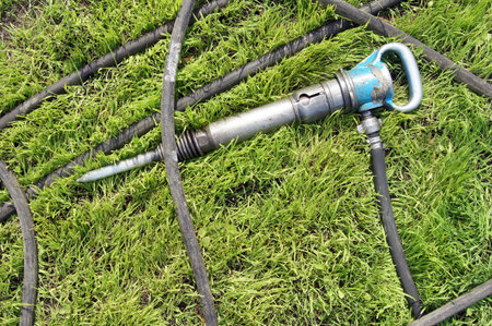 Jackhammer on a green lawn
