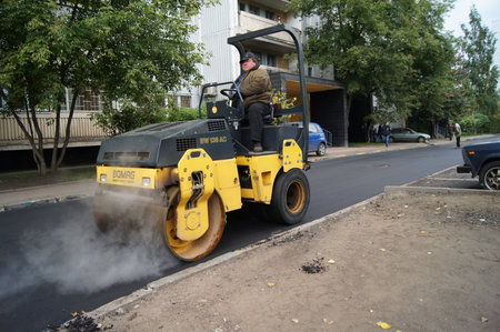 Packing of a new asphalt covering on road before an apartment house within the limits of the city program of an accomplishment of domestic territories, on september 30, 2011, in Moscow.のeditorial素材