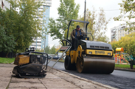 Packing of a new asphalt covering on road before an apartment house within the limits of the city program of an accomplishment of domestic territories, on september 30, 2011, in Moscow.のeditorial素材