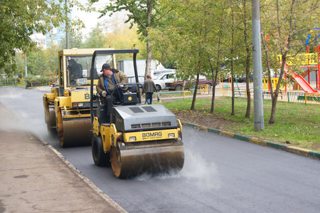 Packing of a new asphalt covering on road before an apartment house within the limits of the city...