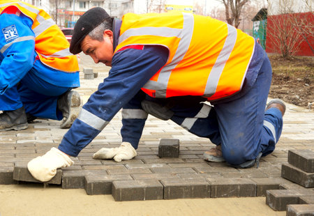 12_04_2012 Moscow, Russia  The workers paves a stone pathのeditorial素材