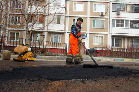 12_04_2012 Moscow, Russia. Road workers repair an asphalt covering after a winter season.のeditorial素材