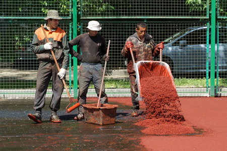 06 06 2013 Moscow  Workers put a rubber polyurethane covering on the sports ground のeditorial素材