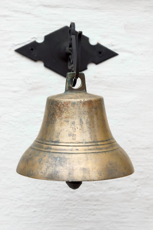 Ancient metal hand bell, it is isolated on the white