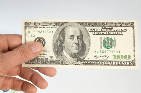 hundred dollars the note in a hand on a white background