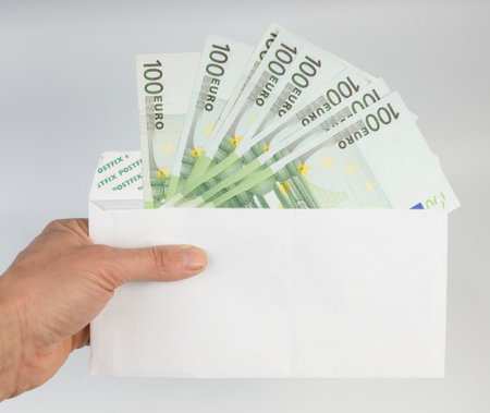 euro the note in a hand on a white backgroundの写真素材