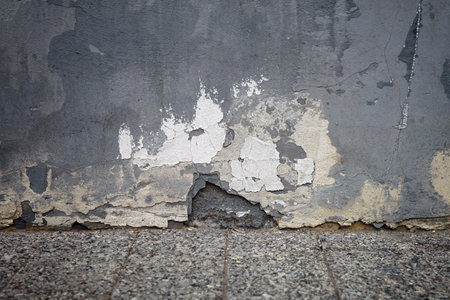 Old painted wall with crumbling plaster and cracks. The picture at the level of the granite floor.の写真素材