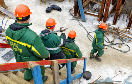 MOSCOW, RUSSIA - February16, 2013: Workers in helmets and uniforms go to the building site. Reconstruction of the Church of the Transfiguration of the Lord on the Transfiguration Square in Moscow.のeditorial素材