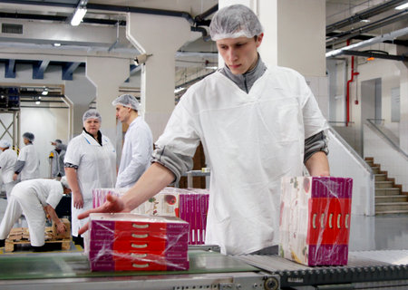 MOSCOW, RUSSIA - JANUARY , 2012: The bakery worker shifts the boxes with the finished pizza. Factory of bakery products in Moscow.のeditorial素材
